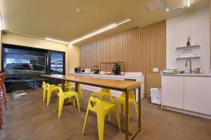 a kitchen with a large wooden table and yellow chairs at js 부티크 호텔 동탄 in Hwaseong