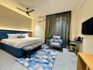 a hotel room with a bed and a chair at Kaysons hotel in Hyderabad