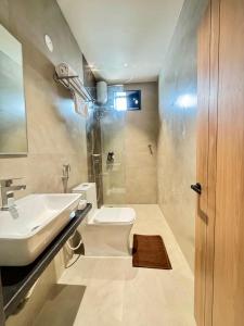 a bathroom with a white toilet and a sink at Kaysons hotel in Hyderabad
