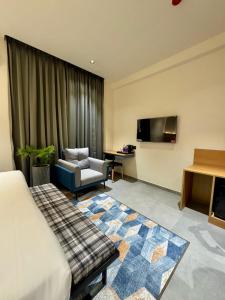 a hotel room with a bed and a chair and a tv at Kaysons hotel in Hyderabad
