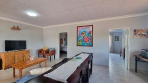 a living room with a dining table and a tv at Maggie's Farm Stay in Khanzi