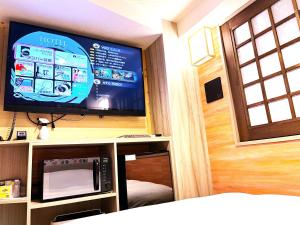 a room with a tv and a microwave at Hotel Opera in Tokyo