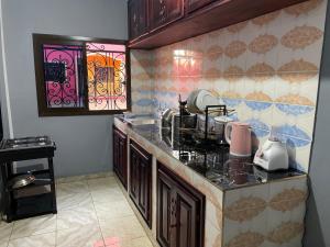 a kitchen with a stove and a counter top at NGK Hôtel Apartment in Bafoussam