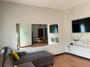 a living room with a couch and a large mirror at Spacious one bedroom Bangalow -8E3 in Kampala