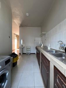 a kitchen with a sink and a washing machine at Spacious one bedroom Bangalow -8E3 in Kampala