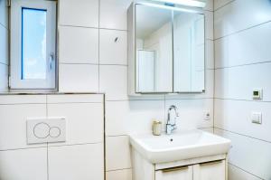 a white bathroom with a sink and a mirror at Ferienwohnung Familiengarten in Volders