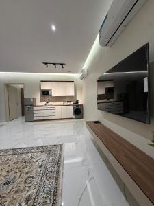 a large kitchen with white appliances and a rug at نسيم العلا - Naseem AlUla in Al-ʿUla +4 photos