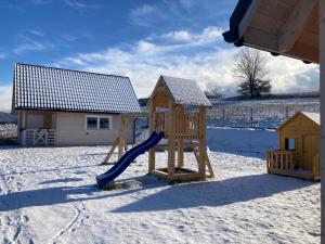 a playground in the snow with a slide at JAFERÓWKA Domki w górach SAUNA JACUZZI in Żywiec