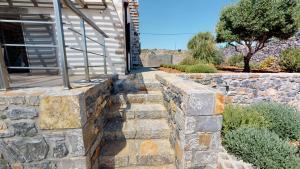 a stone retaining wall in front of a house at Charlise Luxury Villa by Cretevasion in Anópolis