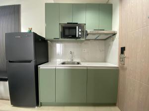a small kitchen with a sink and a refrigerator at 2BR Unit at Hill Residences I Free Parking in Manila