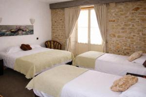 a hotel room with three beds and a window at Relais de Bèze in Bèze