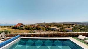 a swimming pool with a view of a house at Charlise Luxury Villa by Cretevasion in Anópolis