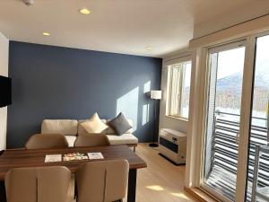 a living room with a couch and a table at ニセコ泉居アパートメント in Kutchan