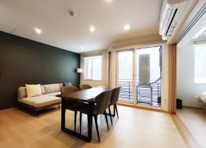 a living room with a table and a couch at ニセコ泉居アパートメント in Kutchan