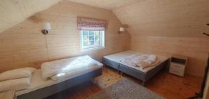 an attic bedroom with two beds and a window at Sunset Cabin in Ålesund