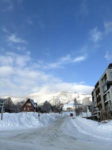 a road covered in snow next to a building at ニセコ泉居アパートメント in Kutchan