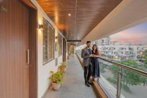 a man and woman standing on the balcony of a building at FabHotel RK Inn in Pune