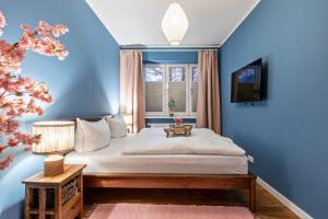 a blue bedroom with a bed and a window at FABEL Apartments am Hbf in Berlin