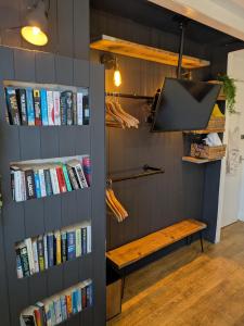 a book shelf filled with books next to a bench at Boutique Coastal appt nr Edinburgh in Saint Davids