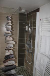 a group of rocks in a bathroom with a shower at Relais de Bèze in Bèze