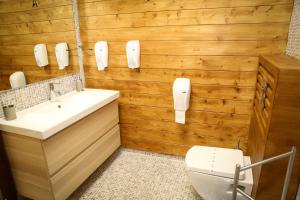 a bathroom with wooden walls and a sink and a toilet at VIP House Glavatarski Han in Glavatartsi +42 photos