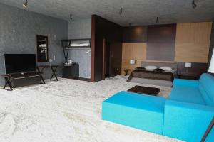 ein Wohnzimmer mit einer blauen Couch und einem Bett in der Unterkunft VIP House Glavatarski Han in Glavatartsi