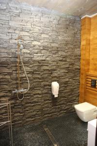 a bathroom with a stone wall and a toilet at VIP House Glavatarski Han in Glavatartsi