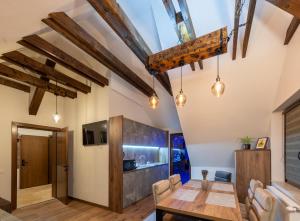 a dining room with wooden table and chairs and wooden beams at DIM Studio in Braşov
