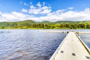a dock on a lake with mountains in the background at Sea Treasures Inn #210 in Rockaway Beach
