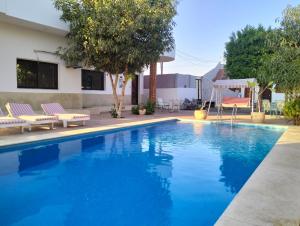 a swimming pool with blue water in a yard at Villa River Nile in Al Qurnah