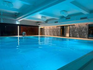 a large swimming pool with blue lighting at Sinaia Mountain View Residence Belleview in Sinaia