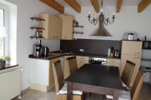 a kitchen with a table and chairs in a kitchen at Luettje-Glueck-2 in Pogum +15 photos