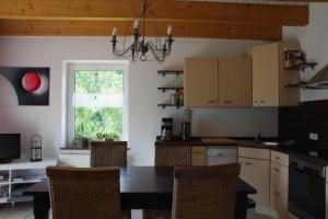 a kitchen with a table and chairs and a window at Luettje-Glueck-2 in Pogum