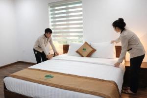 two people standing around a bed in a room at Nice Dream Hotel in Yen