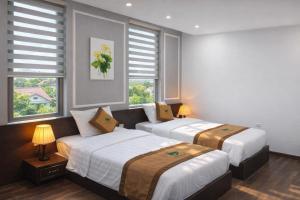 two beds in a room with two windows at Nice Dream Hotel in Yen