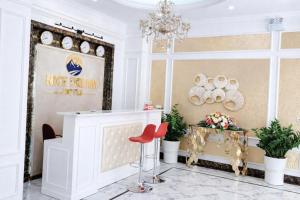a white lobby with a chandelier and red chairs at Nice Dream Hotel in Yen
