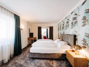 a hotel room with a large bed and a window at Hotel Hirlanda in Zürs am Arlberg