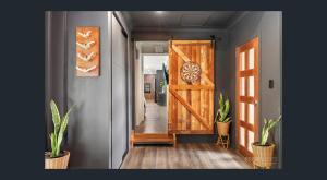 a hallway with a wooden door and potted plants at Between Trees and Tide in Torquay