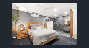 a bedroom with a bed and a bathroom at Between Trees and Tide in Torquay