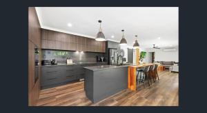 a large kitchen with a counter and a dining room at Between Trees and Tide in Torquay +21 photos