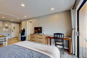 a bedroom with a bed and a desk and a television at Sea Treasures Inn #211 in Rockaway Beach +15 photos