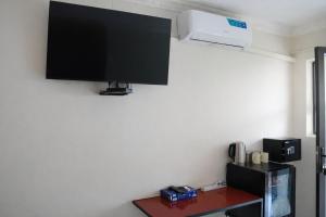 a flat screen tv hanging on a wall at Bougainvilla Kolwezi Guesthouse in Kolwezi