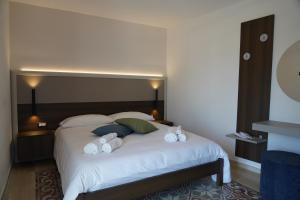 a bedroom with a large white bed with towels on it at Mille Mt Suites - Cercemaggiore in Cercemaggiore