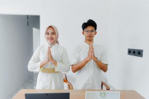 a man and a woman standing in front of a table praying at Ayodhya Villa Utari - North Wings in Yogyakarta +31 photos