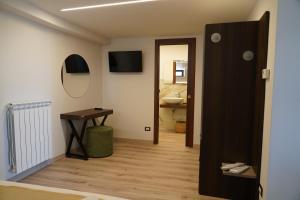 a hallway with a table and a mirror and a bathroom at Mille Mt Suites - Cercemaggiore in Cercemaggiore +47 photos
