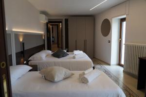 a room with three beds with white sheets and pillows at Mille Mt Suites - Cercemaggiore in Cercemaggiore