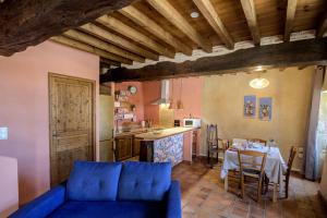 a living room with a blue couch and a table at Clos Baroanni - Gîte Terra in Terraube +19 photos