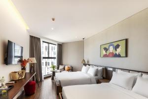 a hotel room with two beds and a tv at Mandala Sands Mũi Né in Phan Thiet +63 photos