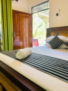 a bed with a rolled up towel on it at Samson's Home in Hiriketiya