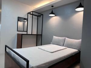 a bedroom with a bed with white sheets and two lights at Capitol Tourist Inn 2026 in Cebu City